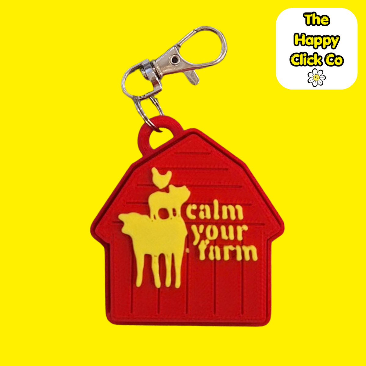 A red barn shaped  fidget clicker keychain with  yellow farm animals and calm your farm text in the center and a silver clasp at the top, shown on a bright yellow background. A 'The Happy Click Co' logo is visible in the top right corner.